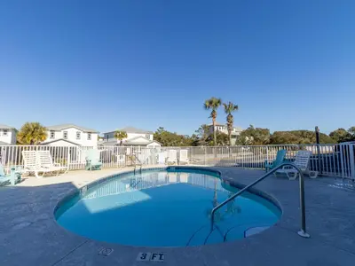 a swimming pool in a yard with a fence at Sunset On Seabreeze in Inlet Beach