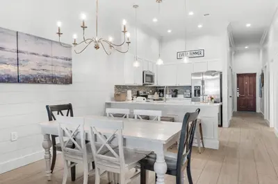 a kitchen and dining room with a table and chairs at The Village Happy Life Condo - Private Beach Access Pool & Hot Tub in Rosemary Beach