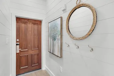 a hallway with a mirror and a door at The Village Happy Life Condo - Private Beach Access Pool & Hot Tub in Rosemary Beach