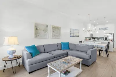 a living room with a couch and a table at The Village Happy Life Condo - Private Beach Access Pool & Hot Tub in Rosemary Beach