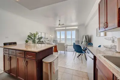 a kitchen with a counter and a dining room at Laketown Wharf 2115 Penthouse with Gulf Views in PCB - Sleeps 6 in Panama City Beach