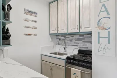 a white kitchen with a stove and a sink at Beach Front Ocean View Condo - Top of the Gulf 804 in Panama City Beach