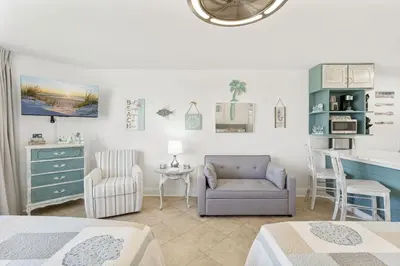 a bedroom with a bed and a chair and a desk at Beach Front Ocean View Condo - Top of the Gulf 804 in Panama City Beach