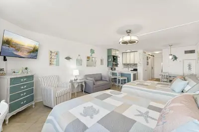 a bedroom with two beds and a living room at Beach Front Ocean View Condo - Top of the Gulf 804 in Panama City Beach