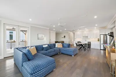 a living room with two blue couches and a kitchen at Four Blue Palms by 30A Escapes in Seacrest