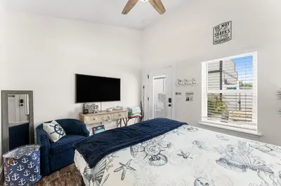 a bedroom with a bed and a flat screen tv at Tiny Treasure by Nautical Properties Vacation Rentals in Panama City Beach