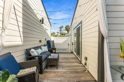 a patio with a couch and chairs on a house at Tiny Treasure by Nautical Properties Vacation Rentals in Panama City Beach