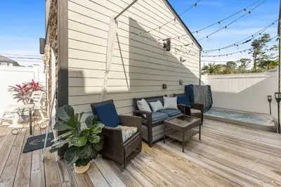 a patio with a couch and chairs on a deck at Tiny Treasure by Nautical Properties Vacation Rentals in Panama City Beach