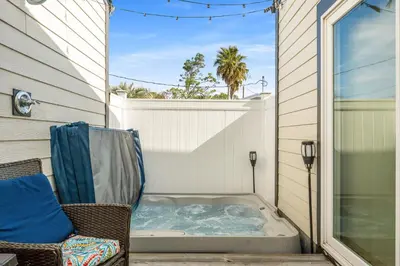 a jacuzzi tub sitting on a porch with a chair at Tiny Treasure by Nautical Properties Vacation Rentals in Panama City Beach