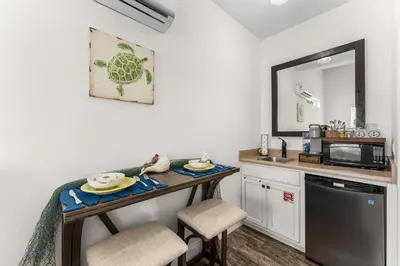 a small kitchen with a table and a microwave at Tiny Treasure by Nautical Properties Vacation Rentals in Panama City Beach