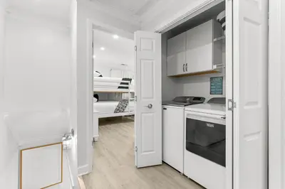 a small kitchen with white cabinets and a sink at Gulf Highlands #177 by Nautical Properties in Panama City Beach