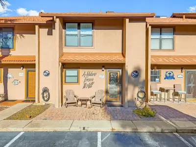 a building with chairs sitting outside of it at Gulf Highlands #177 by Nautical Properties in Panama City Beach