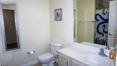 a bathroom with a toilet and a sink and a mirror at Ocean Front Studio with Epic Gulf Views in Panama City Beach