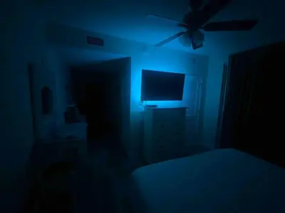 a dark room with a bed and a television at Ocean Front Studio with Epic Gulf Views in Panama City Beach