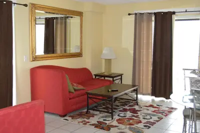 a living room with a red couch and a table at The Summit Condominiums in Panama City Beach