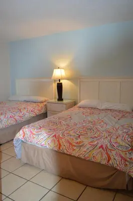 a bedroom with two beds and a lamp on a night stand at The Summit Condominiums in Panama City Beach