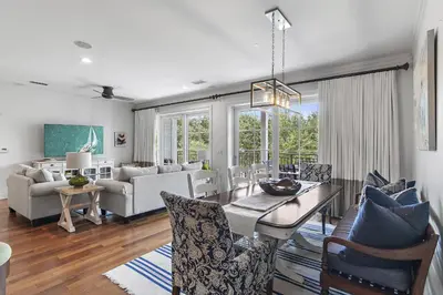a dining room and living room with a table and chairs at WaterHouse 202 in Inlet Beach
