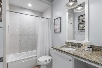 a white bathroom with a toilet and a sink at WaterHouse 202 in Inlet Beach