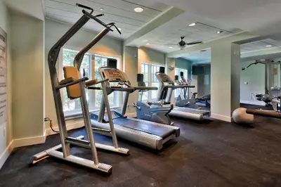 a gym with several tread machines in a room at WaterHouse 202 in Inlet Beach