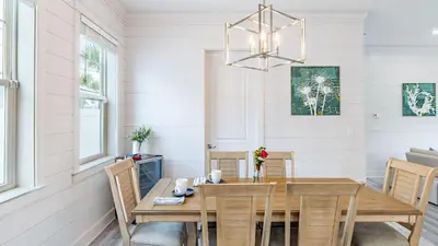 a dining room with a wooden table and chairs at Modern 5BDR w Private Pool 2 min Walk to the Beach Montoute by AvantStay in Panama City Beach