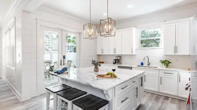 a kitchen with white cabinets and a large island at Modern 5BDR w Private Pool 2 min Walk to the Beach Montoute by AvantStay in Panama City Beach