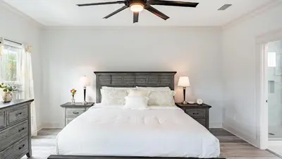 a bedroom with a large bed with a ceiling fan at Modern 5BDR w Private Pool 2 min Walk to the Beach Montoute by AvantStay in Panama City Beach
