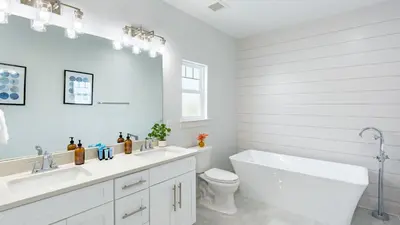 a white bathroom with a tub and a sink and a toilet at Modern 5BDR w Private Pool 2 min Walk to the Beach Montoute by AvantStay in Panama City Beach