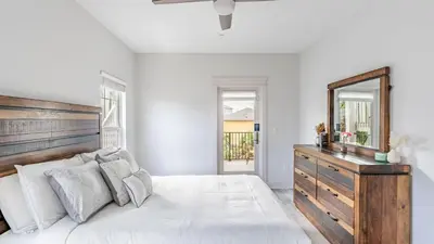 a bedroom with a large white bed and a mirror at Modern 5BDR w Private Pool 2 min Walk to the Beach Montoute by AvantStay in Panama City Beach