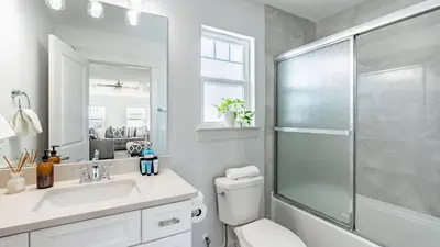a bathroom with a shower and a toilet and a sink at Modern 5BDR w Private Pool 2 min Walk to the Beach Montoute by AvantStay in Panama City Beach