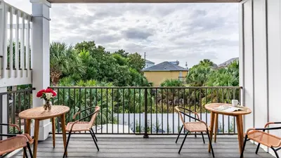 a balcony with a table and chairs and a view at Modern 5BDR w Private Pool 2 min Walk to the Beach Montoute by AvantStay in Panama City Beach