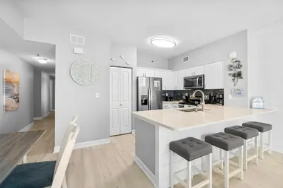 a kitchen with white cabinets and a large island with bar stools at Shores Of Panama #0924 in Panama City Beach