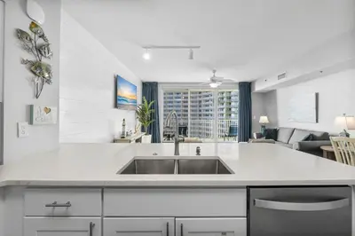 a kitchen with a sink and a living room at Shores Of Panama #0924 in Panama City Beach