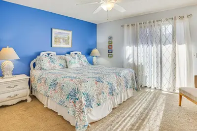 a blue bedroom with a bed and a blue wall at Walk to Beach PCB Gem with Community Pool Access! in Panama City Beach