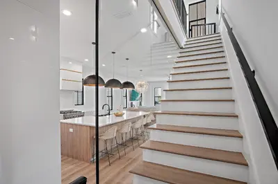 a staircase leading to the kitchen and dining room of a house at LegaSea on 30A in Inlet Beach