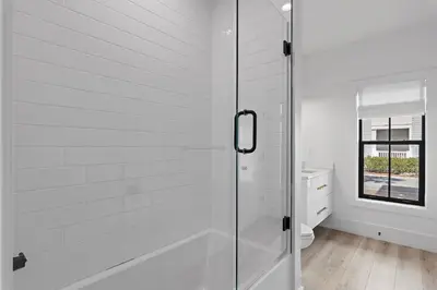 a white bathroom with a shower and a toilet at LegaSea on 30A in Inlet Beach