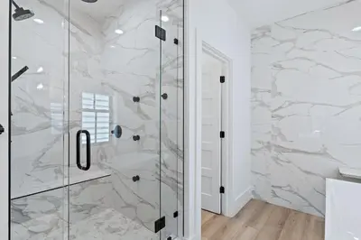 a bathroom with a shower with marble walls at LegaSea on 30A in Inlet Beach