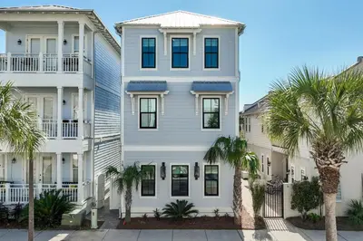 a white house with palm trees in front of it at LegaSea on 30A in Inlet Beach