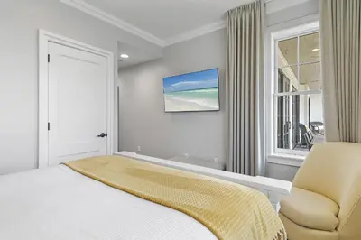 a bedroom with a bed and a chair and a window at WaterHouse 304- Open Air in Inlet Beach