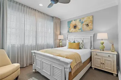 a bedroom with a white bed and a chair at WaterHouse 304- Open Air in Inlet Beach