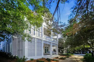 a white house with white shutters and trees at Harp's Haven Main House in Inlet Beach