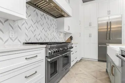 a kitchen with white cabinets and a stove at Harp's Haven Main House in Inlet Beach