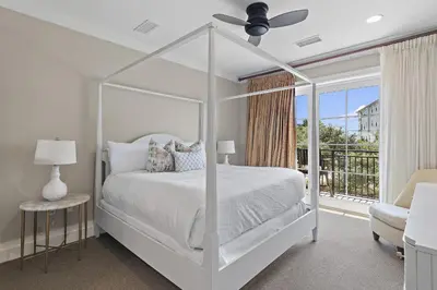 a white bedroom with a white canopy bed and a balcony at WaterHouse 204 in Inlet Beach