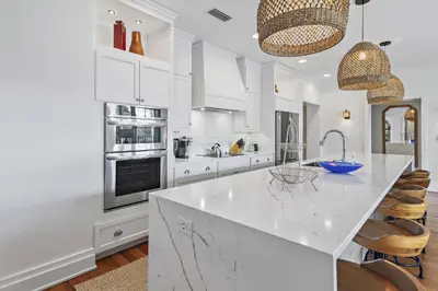 a kitchen with white cabinets and a large white island at WaterHouse 204 in Inlet Beach