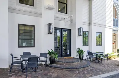 a patio with chairs and tables in front of a building at WaterHouse 204 in Inlet Beach