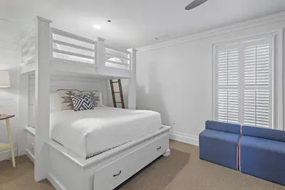 a white bedroom with a bunk bed and a blue couch at WaterHouse 204 in Inlet Beach