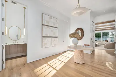a white living room with a table and a mirror at 74 Elysee Court in Inlet Beach