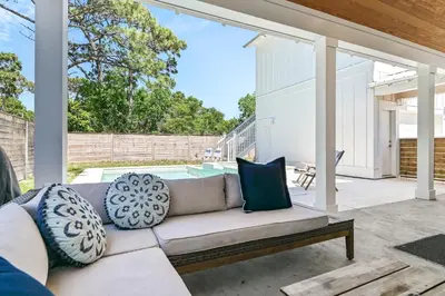 a living room with a couch and a pool at Vitamin Sea of Seagrove in Santa Rosa Beach