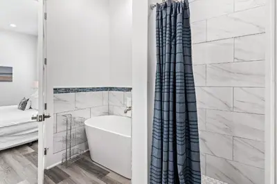 a bathroom with a tub and a shower curtain at Vitamin Sea of Seagrove in Santa Rosa Beach