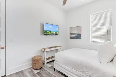 a white bedroom with a bed and a table at Vitamin Sea of Seagrove in Santa Rosa Beach