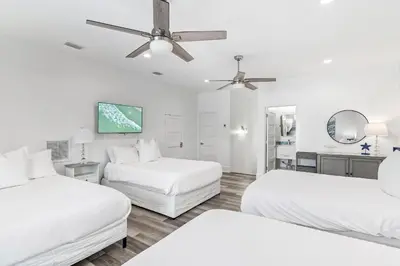 a white room with two beds and a ceiling fan at Vitamin Sea of Seagrove in Santa Rosa Beach